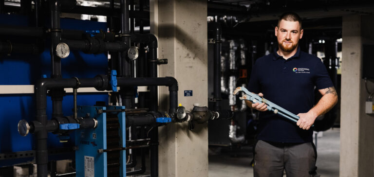 Portrait von Monteur. Er hat eine Rohrzange in der Hand.