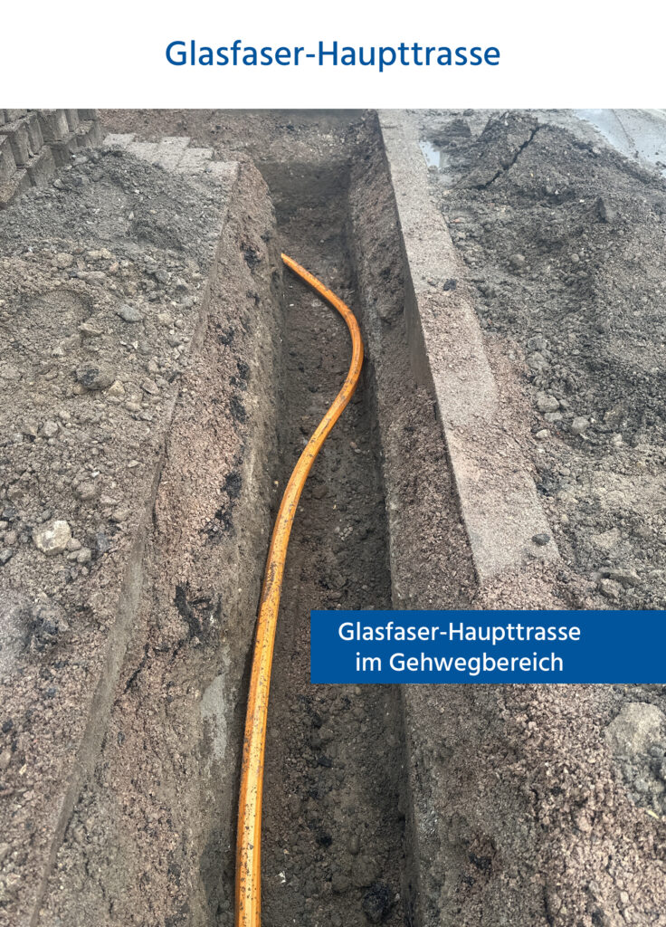 Eine Glasfaser-Hatpttrasse liegt sichtbar im aufgegrabenen Gehwegbereich